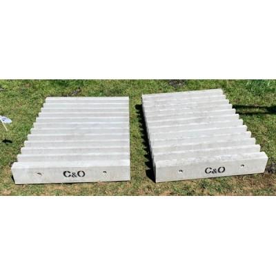 Two ridged concrete cattle stop blocks stamped C&O on grass