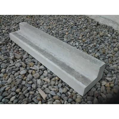 Single L-shaped concrete kerbing piece on gravel